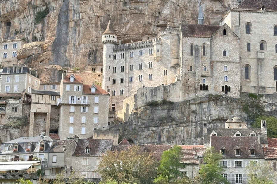 Village à Rocamadour dans le Lot, maisons médiévales superposées à flanc de falaise dominant la vallée verdoyante.