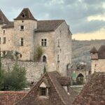 Vue du village médiéval de Saint-Cirq-Lapopie avec ses maisons en pierre et ses toits en lauzes dominant la vallée du Lot