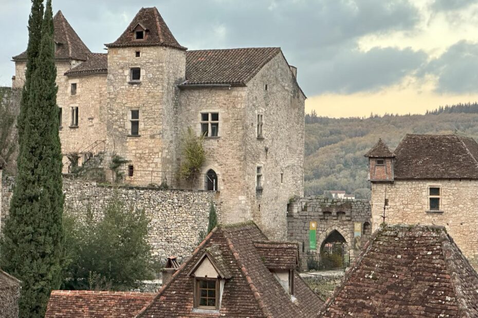 Vue du village médiéval de Saint-Cirq-Lapopie avec ses maisons en pierre et ses toits en lauzes dominant la vallée du Lot